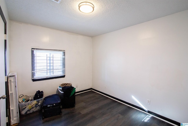 empty room with hardwood / wood-style flooring and a textured ceiling