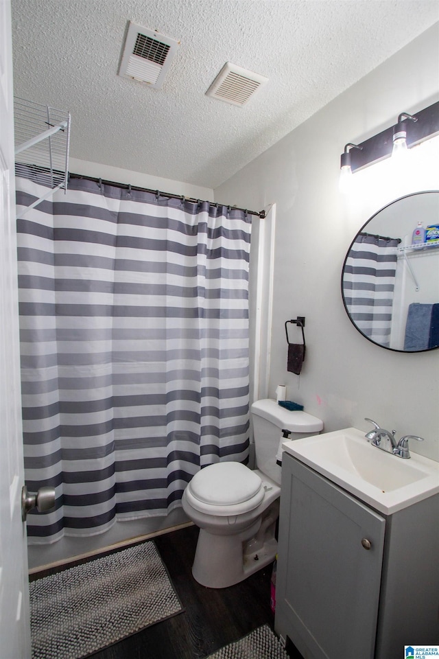 bathroom with toilet, a textured ceiling, wood-type flooring, a shower with shower curtain, and vanity