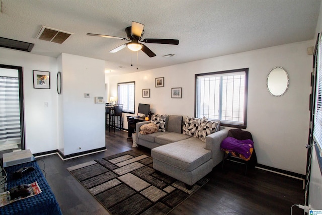 living room featuring a textured ceiling, ceiling fan, and dark hardwood / wood-style floors