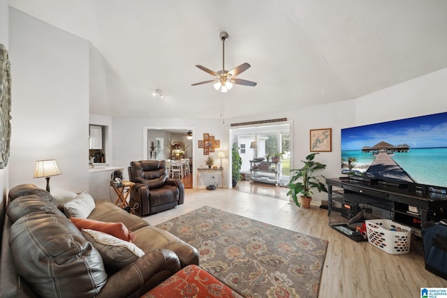 living room with lofted ceiling, ceiling fan, and light hardwood / wood-style floors