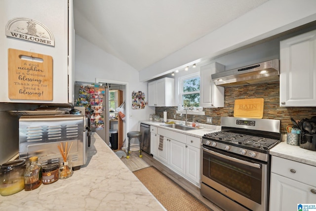 kitchen featuring stainless steel appliances, sink, white cabinets, backsplash, and exhaust hood