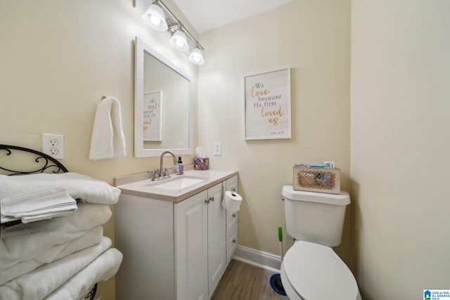 bathroom with toilet, wood-type flooring, and vanity