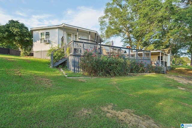 rear view of property featuring a deck and a yard