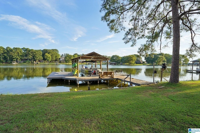 view of dock with a water view and a lawn