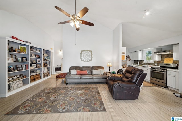 living room with lofted ceiling, ceiling fan, light hardwood / wood-style floors, and sink