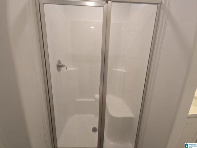 bathroom featuring a shower with door