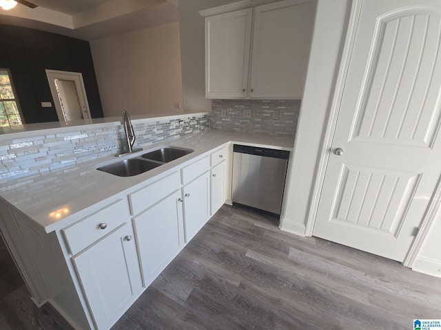 kitchen featuring stainless steel dishwasher, decorative backsplash, white cabinets, wood-type flooring, and sink