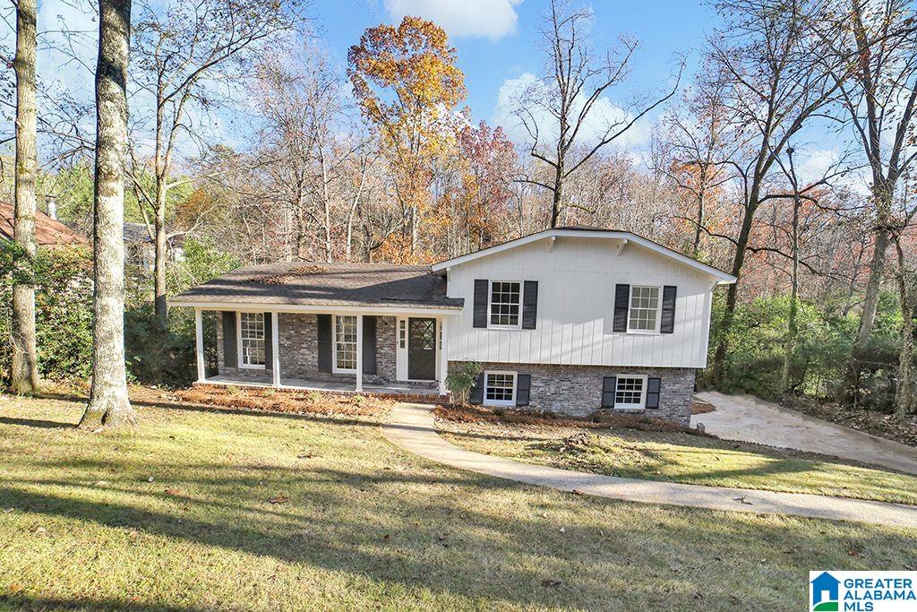 split level home featuring covered porch and a front lawn