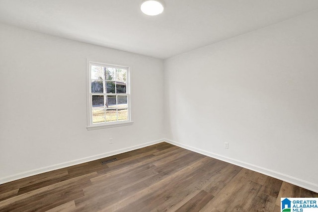 empty room featuring visible vents, baseboards, and wood finished floors