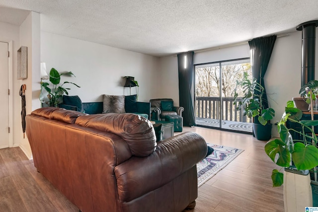 living room with a textured ceiling and light hardwood / wood-style flooring