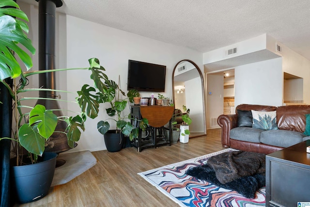 living room featuring a textured ceiling and light wood-type flooring