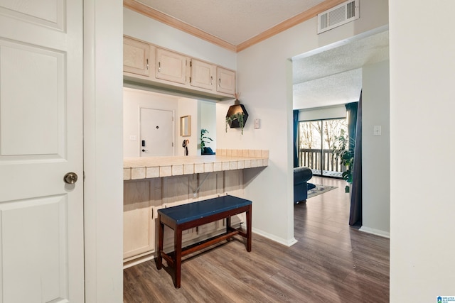 kitchen with a textured ceiling, ornamental molding, tile countertops, and dark wood-type flooring