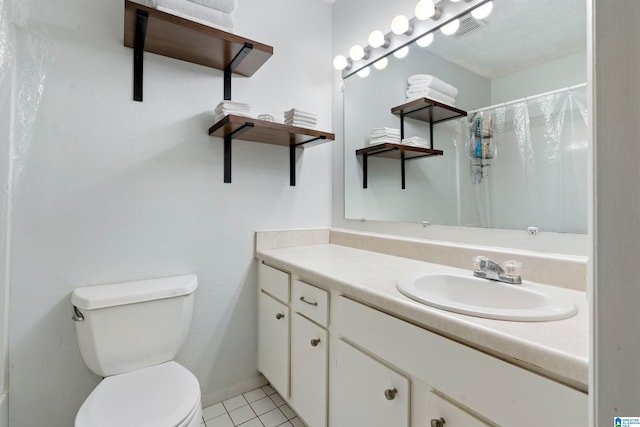 bathroom with toilet, tile patterned floors, walk in shower, and vanity