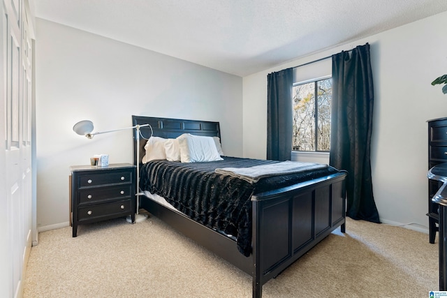 bedroom with a textured ceiling and light colored carpet