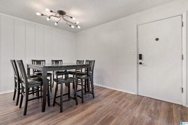 dining area featuring a textured ceiling and hardwood / wood-style floors