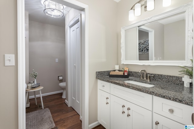 bathroom with toilet, wood-type flooring, and vanity