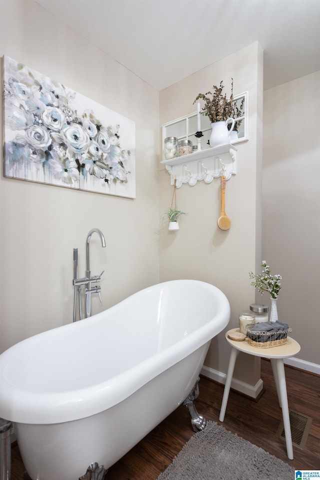 bathroom with a tub and wood-type flooring