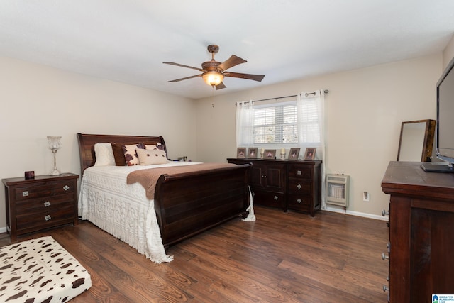 bedroom featuring ceiling fan, heating unit, and dark hardwood / wood-style floors