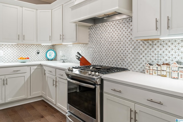 kitchen with stainless steel gas range, custom exhaust hood, white cabinetry, decorative backsplash, and dark hardwood / wood-style floors