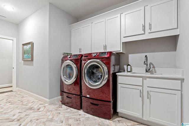 washroom with sink, independent washer and dryer, and cabinets