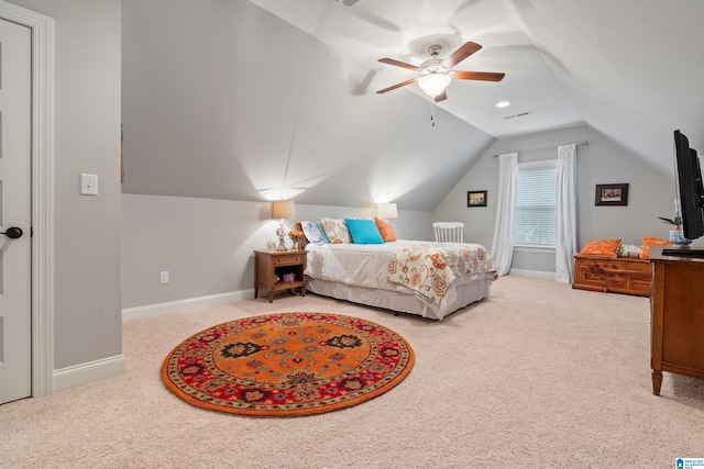 carpeted bedroom with ceiling fan and vaulted ceiling