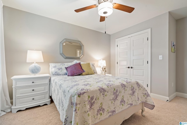 carpeted bedroom with ceiling fan and a closet