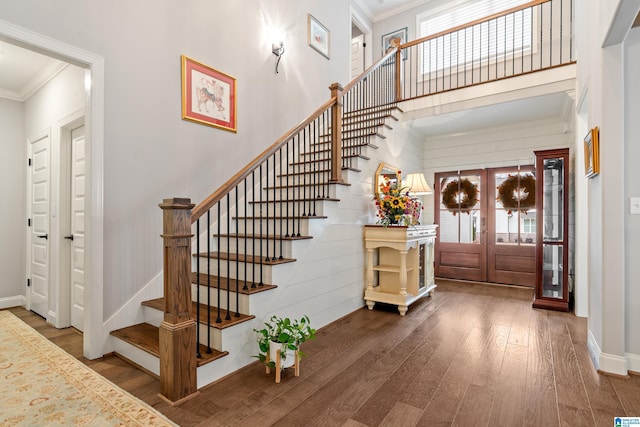 entrance foyer with hardwood / wood-style floors, crown molding, and french doors