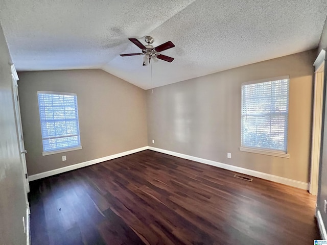 spare room with a textured ceiling, ceiling fan, vaulted ceiling, and dark hardwood / wood-style flooring