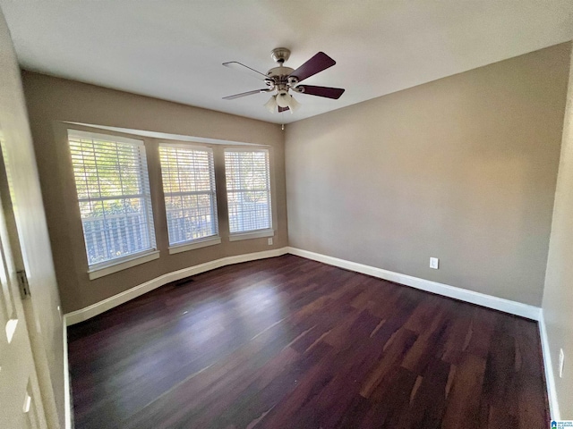 spare room with dark hardwood / wood-style flooring, ceiling fan, and plenty of natural light