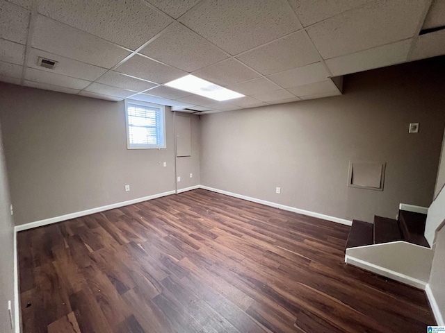 basement featuring dark hardwood / wood-style flooring and a drop ceiling