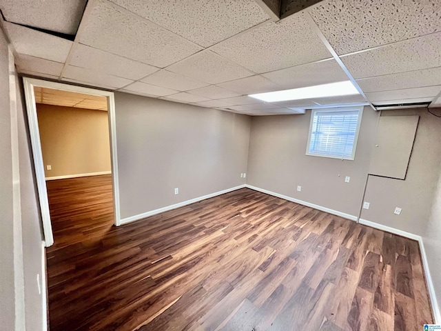 basement featuring a paneled ceiling and hardwood / wood-style floors