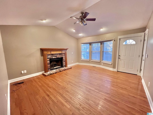 unfurnished living room with a fireplace, ceiling fan, vaulted ceiling, and light hardwood / wood-style flooring