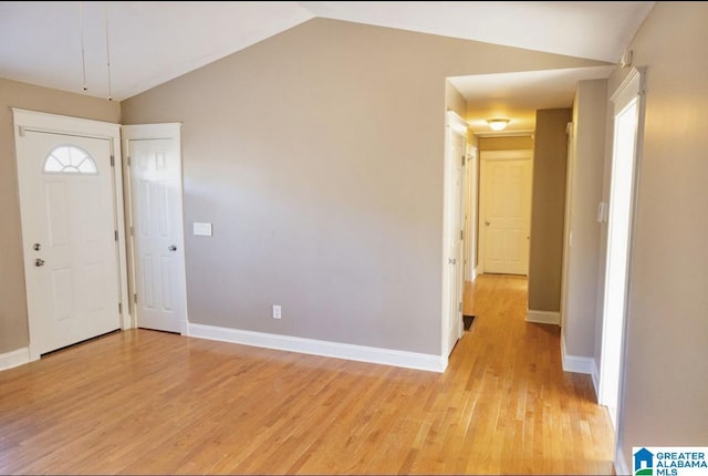 entryway with light hardwood / wood-style floors and vaulted ceiling