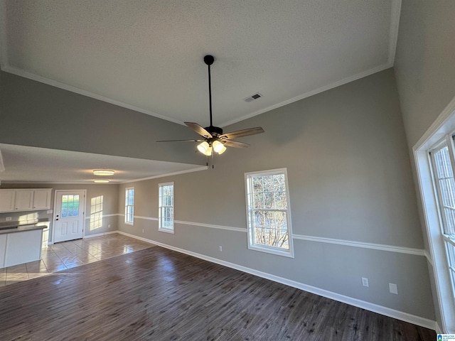 unfurnished living room with ornamental molding, ceiling fan, hardwood / wood-style floors, and a textured ceiling