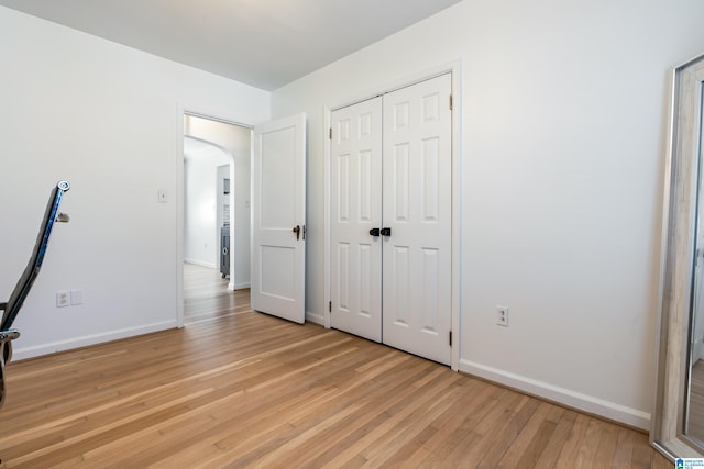 unfurnished bedroom with light hardwood / wood-style flooring and a closet