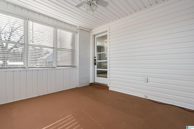 unfurnished sunroom with ceiling fan