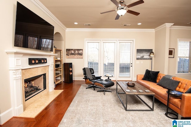 living room with hardwood / wood-style flooring, plenty of natural light, and ornamental molding