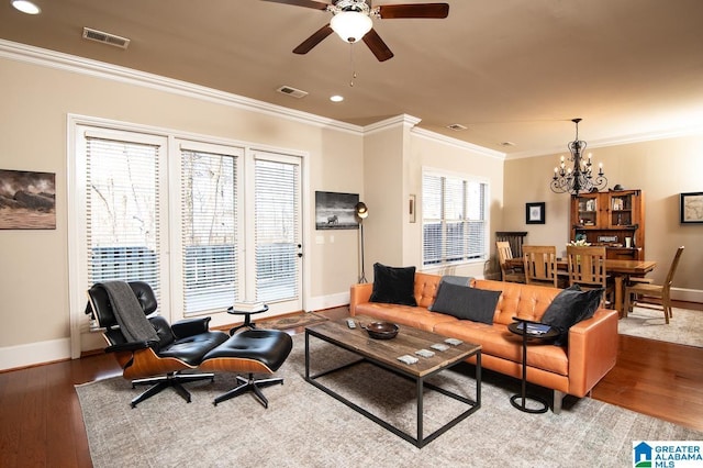 living room featuring wood-type flooring, ceiling fan with notable chandelier, and ornamental molding