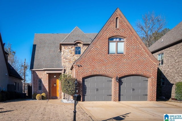 english style home featuring a garage