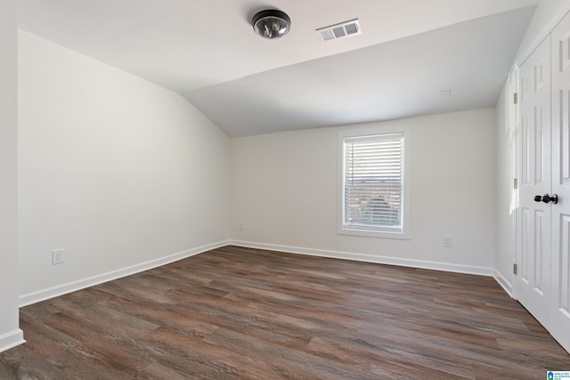 empty room with lofted ceiling and dark hardwood / wood-style flooring