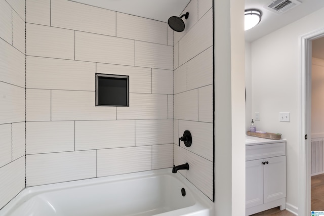 bathroom with tiled shower / bath and vanity