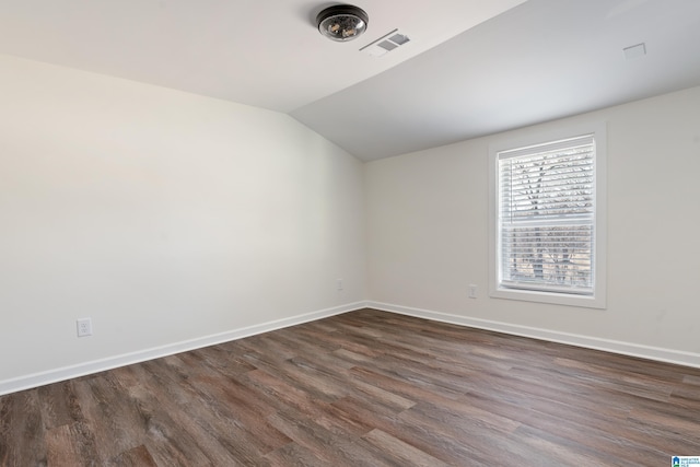 unfurnished room featuring dark wood-type flooring and vaulted ceiling