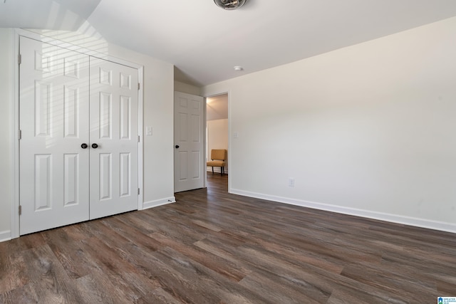 unfurnished bedroom featuring dark wood-type flooring and a closet