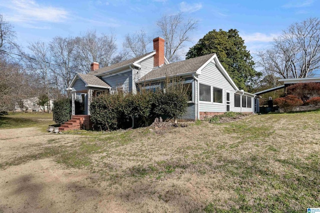 view of side of home featuring a yard and a sunroom