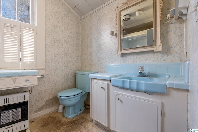 bathroom with toilet, vanity, heating unit, and crown molding