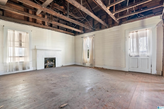 unfurnished living room with a brick fireplace and wood-type flooring