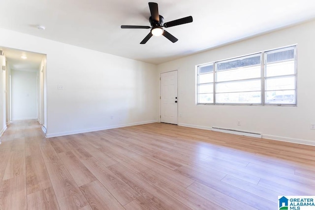 spare room featuring a baseboard radiator, light wood-type flooring, and ceiling fan