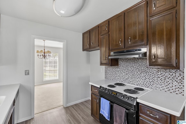 kitchen featuring an inviting chandelier, backsplash, electric stove, light hardwood / wood-style flooring, and dark brown cabinetry