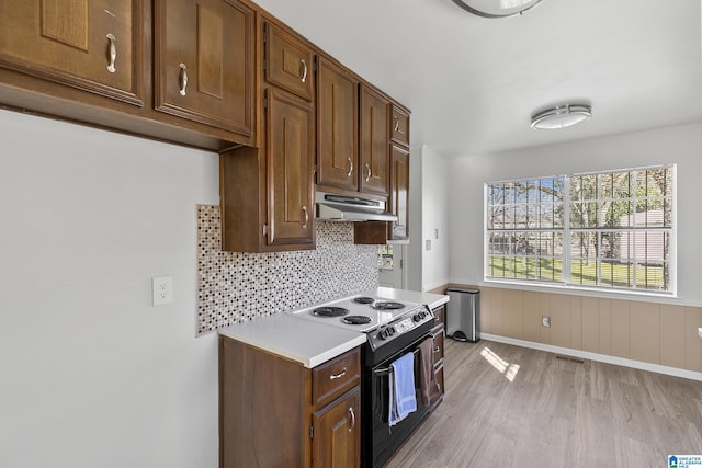 kitchen with backsplash, range with electric cooktop, and light hardwood / wood-style floors