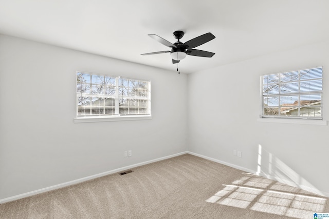 spare room with ceiling fan, carpet flooring, and a healthy amount of sunlight